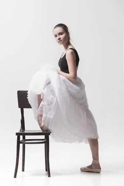La ballerine adolescente en paquet blanc posant près de la chaise — Photo