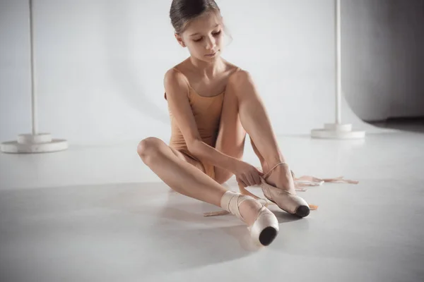 Bela pequena bailarina colocando em pé sapatos pointe — Fotografia de Stock