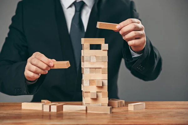 Uomo e cubi di legno sul tavolo. Concetto di gestione — Foto Stock