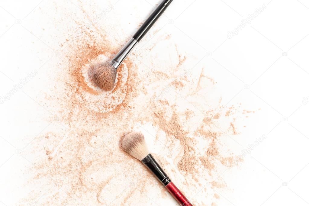 Close-up of crushed mineral shimmer powder golden color with makeup brush