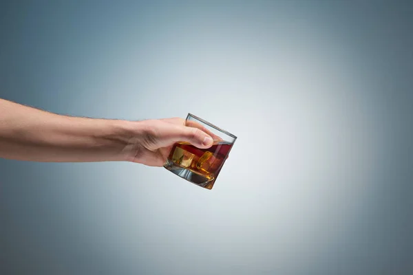 Mano sosteniendo un vaso de whisky — Foto de Stock