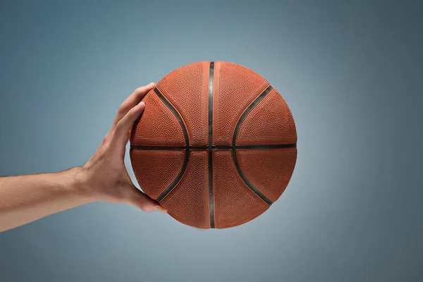 Χαμηλό βασικό στιγμιότυπο από ένα χέρι που κρατά μια μπάλα μπάσκετ — Φωτογραφία Αρχείου