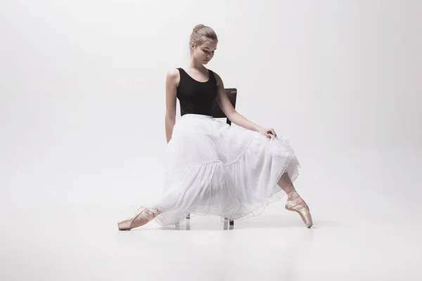 A bailarina adolescente no pacote branco sentado na cadeira — Fotografia de Stock