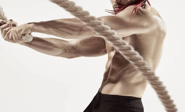 Homem muscular atraente trabalhando fora com cordas pesadas . — Fotografia de Stock
