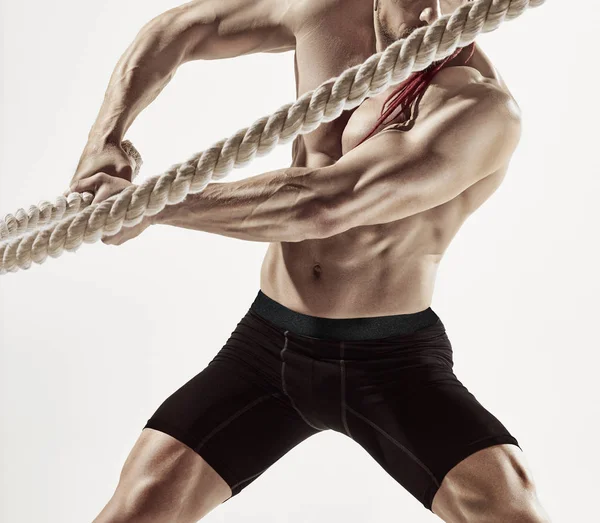 Attractive muscular man working out with heavy ropes. — Stock Photo, Image