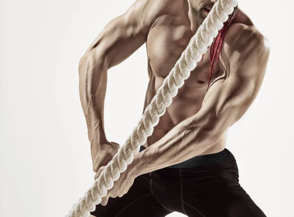 Attractive muscular man working out with heavy ropes. — Stock Photo, Image