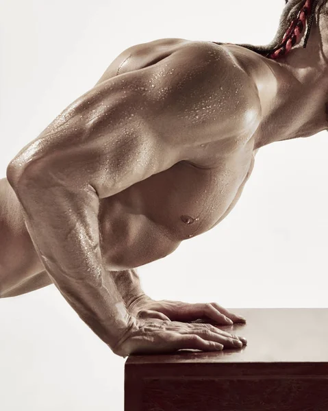 Le beau mec est tordu sur une table dans la salle de gym — Photo