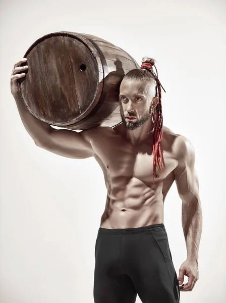 Hombre de fitness con cuerpo perfecto haciendo ejercicios con barril de madera —  Fotos de Stock