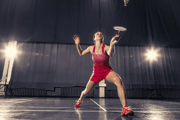 Mujer joven jugando al bádminton en el gimnasio —  Fotos de Stock