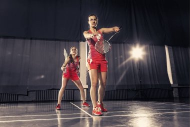 Genç kadın spor salonunda badminton oynarken