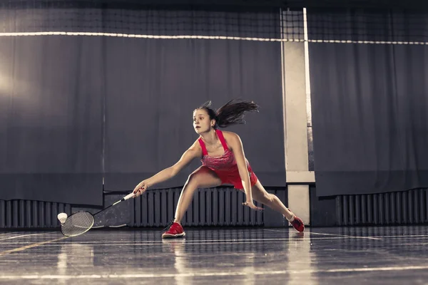 Jovem mulher jogando badminton no ginásio — Fotografia de Stock
