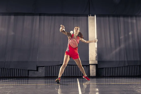 Mujer joven jugando al bádminton en el gimnasio — Foto de Stock