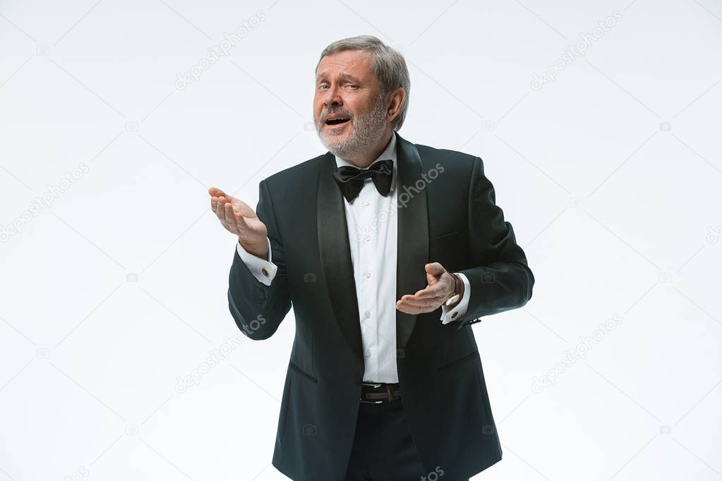 older businessman in a suit with a bow tie, isolated over white