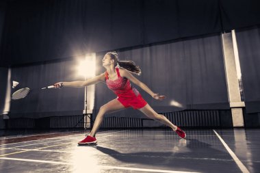 Genç kadın spor salonunda badminton oynarken