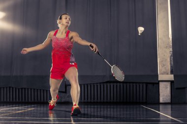 Genç kadın spor salonunda badminton oynarken