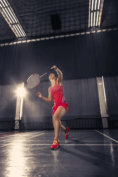 Jonge vrouw spelen badminton op sportschool — Stockfoto