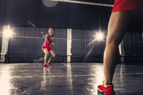 Jovem mulher jogando badminton no ginásio — Fotografia de Stock