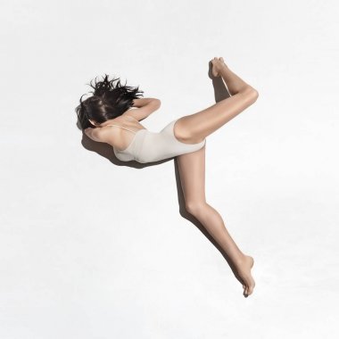 Gri arka plan üzerinde dans bej elbise genç güzel dansçı