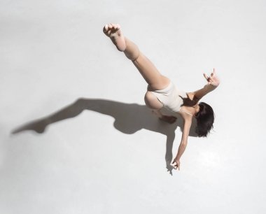Gri arka plan üzerinde dans bej elbise genç güzel dansçı
