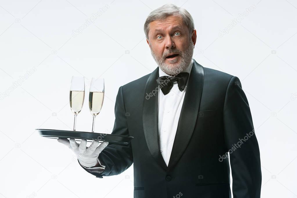 professional waiter in uniform is serving wine
