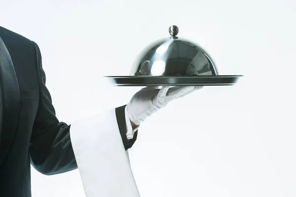 Закрыть руку официанта с подносом и металлическим чехлом крышки — стоковое фото