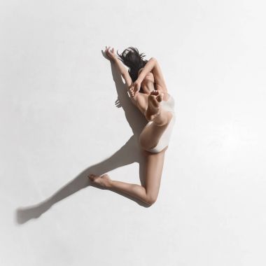 Gri arka plan üzerinde dans bej elbise genç güzel dansçı