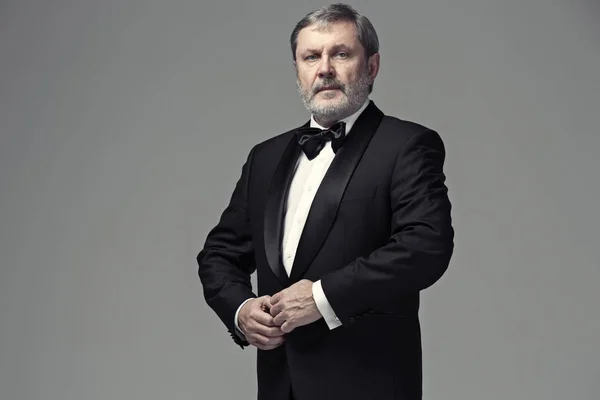 Männlicher Erwachsener mittleren Alters trägt einen Anzug isoliert auf grau — Stockfoto