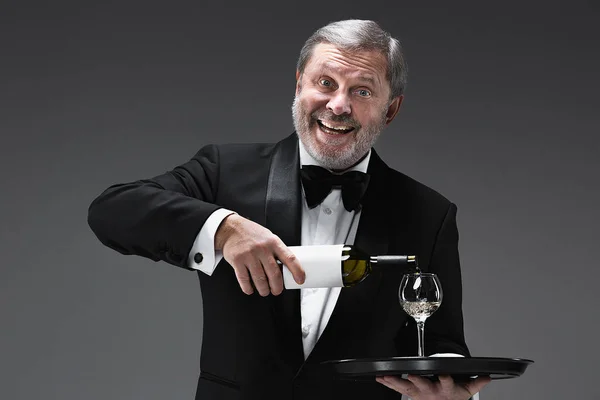 Garçom profissional em uniforme está servindo vinho — Fotografia de Stock