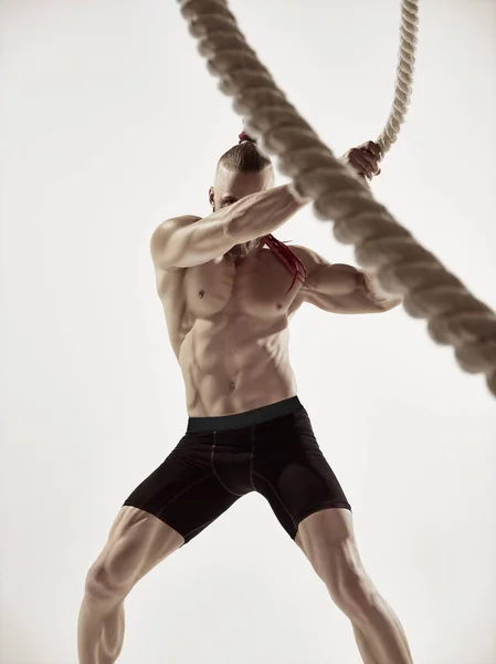 Aantrekkelijke gespierde man uit te werken met zware touwen. — Stockfoto
