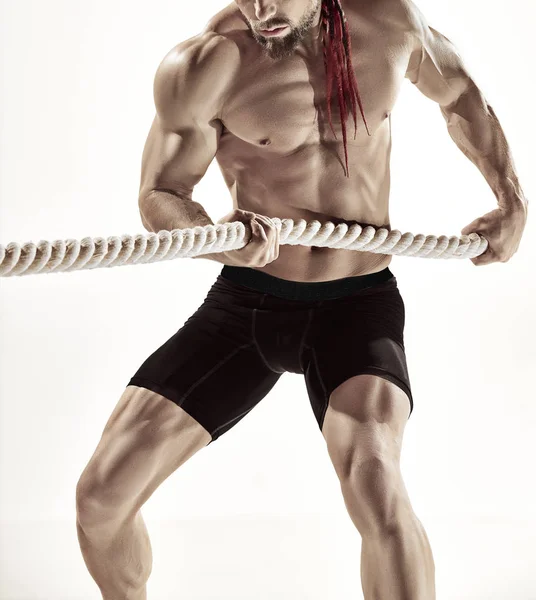 Atractivo hombre musculoso haciendo ejercicio con cuerdas pesadas . — Foto de Stock