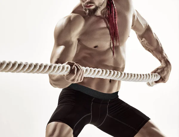 Atractivo hombre musculoso haciendo ejercicio con cuerdas pesadas . — Foto de Stock