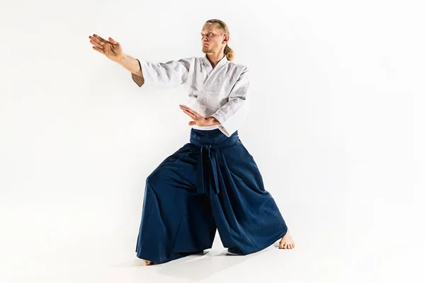 Aikido master praktijken verdediging houding. Gezonde levensstijl en sport concept. Man met baard in witte kimono op witte achtergrond. — Stockfoto