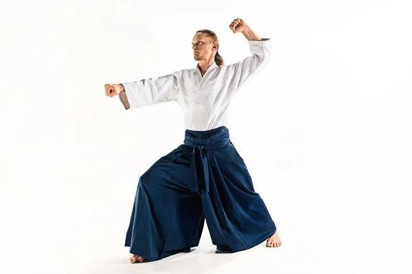 Aikido maestro practica la postura de defensa. Estilo de vida saludable y concepto deportivo. Hombre con barba en kimono blanco sobre fondo blanco . — Foto de Stock