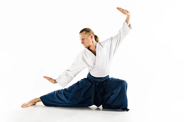 Aikido mester gyakorlatok védelmi testtartás. Egészséges életmód és a Sport koncepció. Férfi szakállal, fehér háttér előtt fehér kimonó. — Stock Fotó