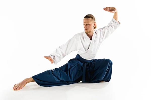 Aikido mester gyakorlatok védelmi testtartás. Egészséges életmód és a Sport koncepció. Férfi szakállal, fehér háttér előtt fehér kimonó. — Stock Fotó