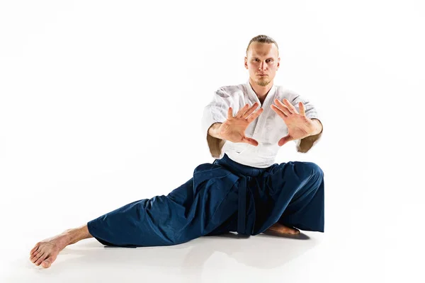 Aikido mester gyakorlatok védelmi testtartás. Egészséges életmód és a Sport koncepció. Férfi szakállal, fehér háttér előtt fehér kimonó. — Stock Fotó
