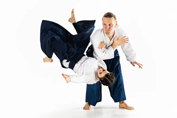 Man and woman fighting at Aikido training in martial arts school