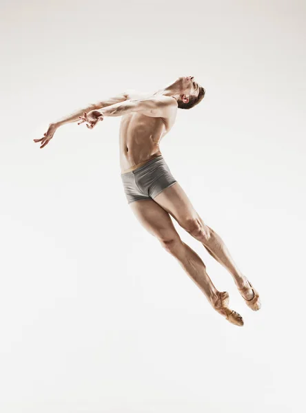 El bailarín de ballet atlético masculino realizando danza aislada sobre fondo blanco . — Foto de Stock