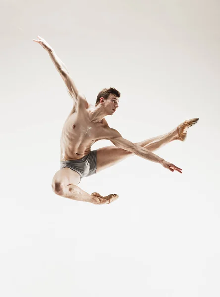 El bailarín de ballet atlético masculino realizando danza aislada sobre fondo blanco . — Foto de Stock