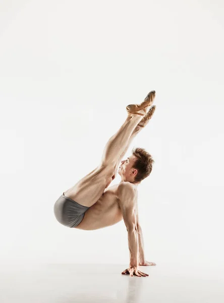 Ballerino di balletto atletico in una forma perfetta che si esibisce sullo sfondo grigio . — Foto Stock