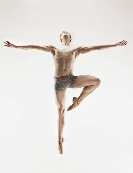 Bailarina de ballet atlética en una forma perfecta actuando sobre el fondo gris . — Foto de Stock