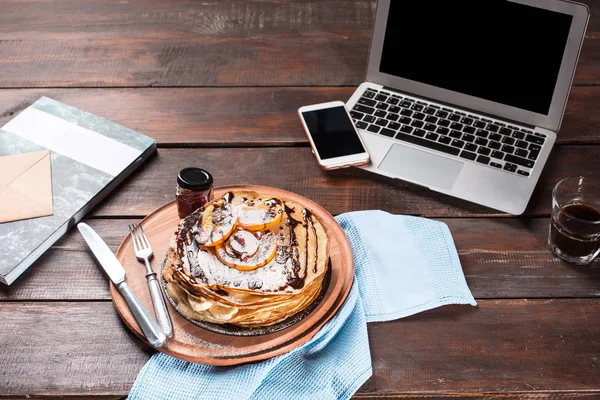 Computer portatile e frittelle con succo di frutta. Colazione sana — Foto Stock