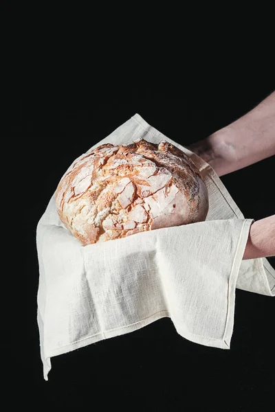 Крупный план мужских рук положить свежий хлеб на черном фоне с копировальным местом для текста — стоковое фото
