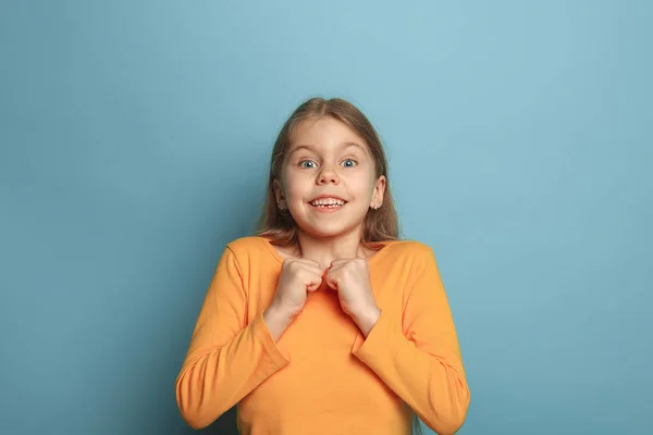 Sürpriz, mutluluk, sevinç, zafer, başarı ve şans. Genç kız mavi bir arka plan üzerinde. Yüz ifadeleri ve insan duyguları kavramı — Stok fotoğraf