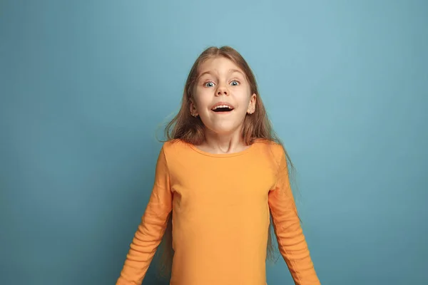 A surpresa, a felicidade, a alegria, a vitória, o sucesso e a sorte. Menina adolescente em um fundo azul. Expressões faciais e conceito de emoções de pessoas — Fotografia de Stock