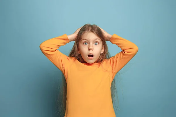 The surprise, happiness, joy, victory, success and luck. Teen girl on a blue background. Facial expressions and people emotions concept