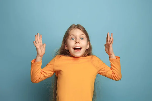 Överraskning, lycka, glädje, seger, framgång och lycka. Teen flicka på en blå bakgrund. Ansikts uttryck och människor känslor koncept — Stockfoto