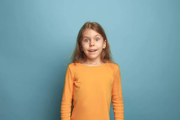 Överraskning, lycka, glädje, seger, framgång och lycka. Teen flicka på en blå bakgrund. Ansikts uttryck och människor känslor koncept — Stockfoto