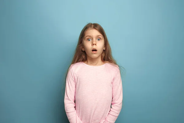 Sürpriz. Genç kız mavi bir arka plan üzerinde. Yüz ifadeleri ve insan duyguları kavramı — Stok fotoğraf