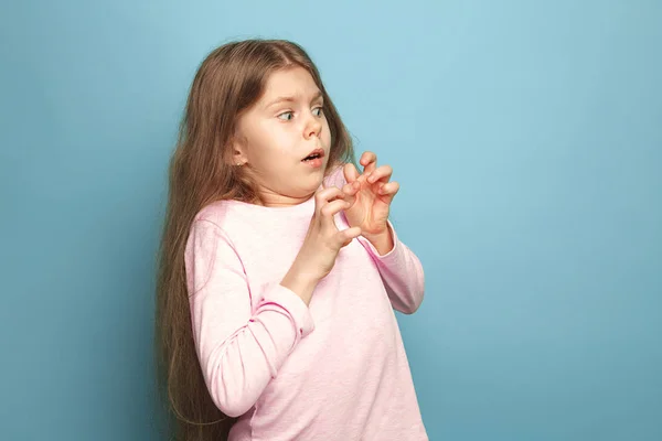 Rädsla. Teen flicka på en blå bakgrund. Ansikts uttryck och människor känslor koncept — Stockfoto